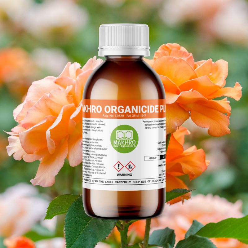 Bottle of Makhro Organicide Plus with flowers in the background