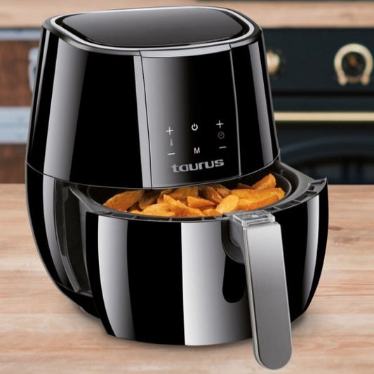 Black taurus air fryer with fries on a wooden surface