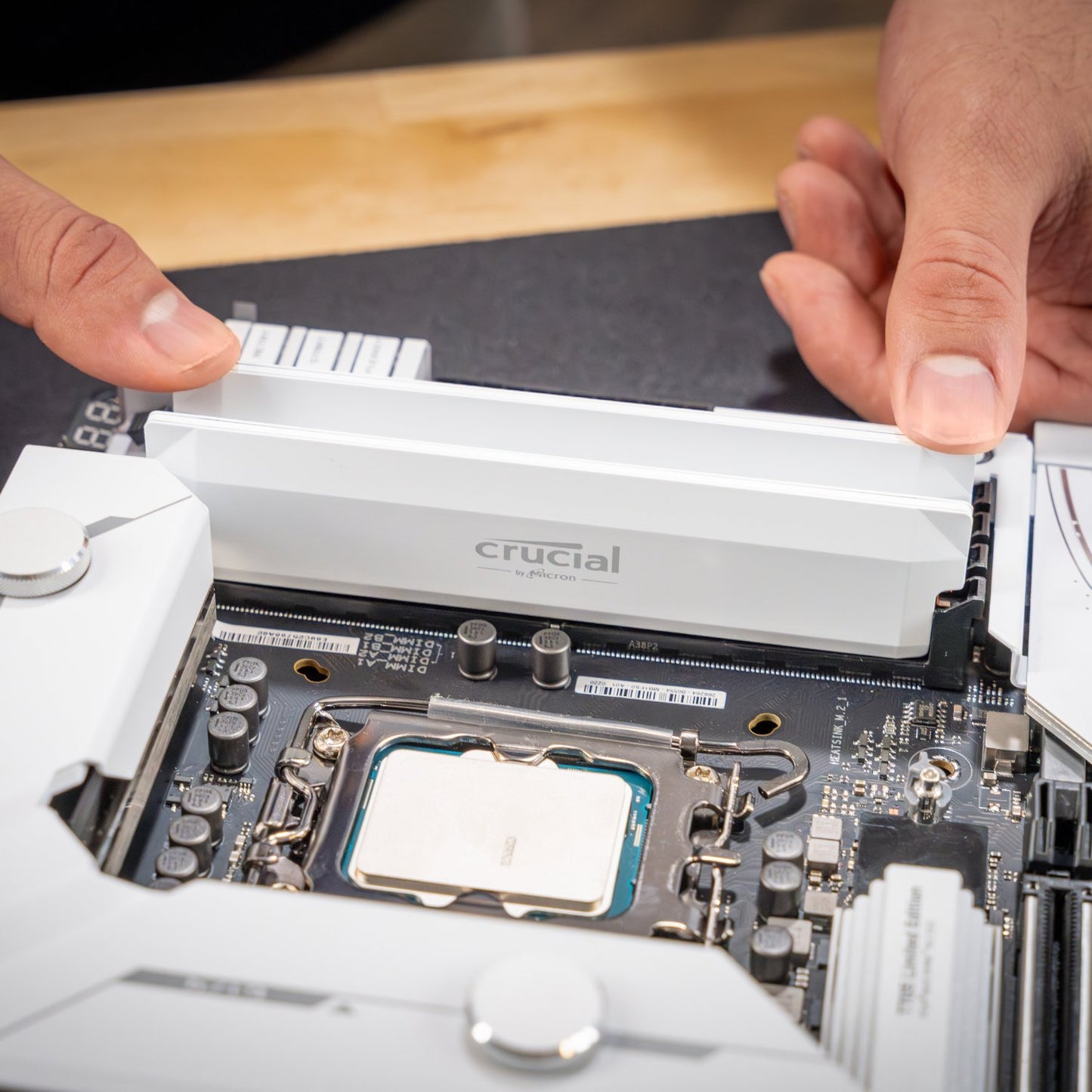 Close-up of a Crucial RAM module being installed on a motherboard.