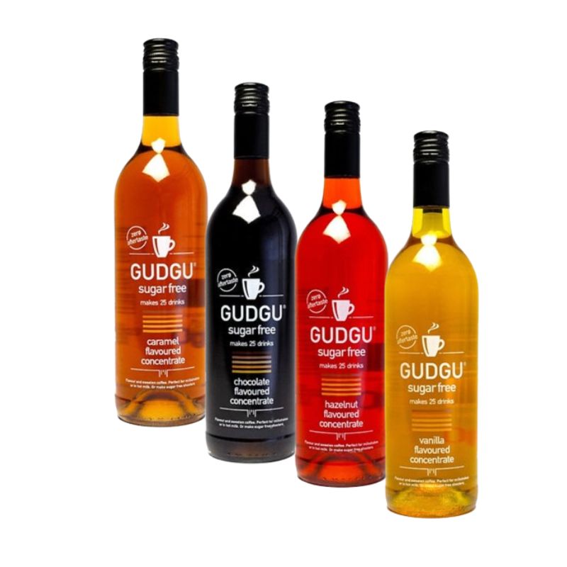 Four bottles of GUDGU sugar-free concentrate for coffee and milkshake, each in different colors representing different flavors.