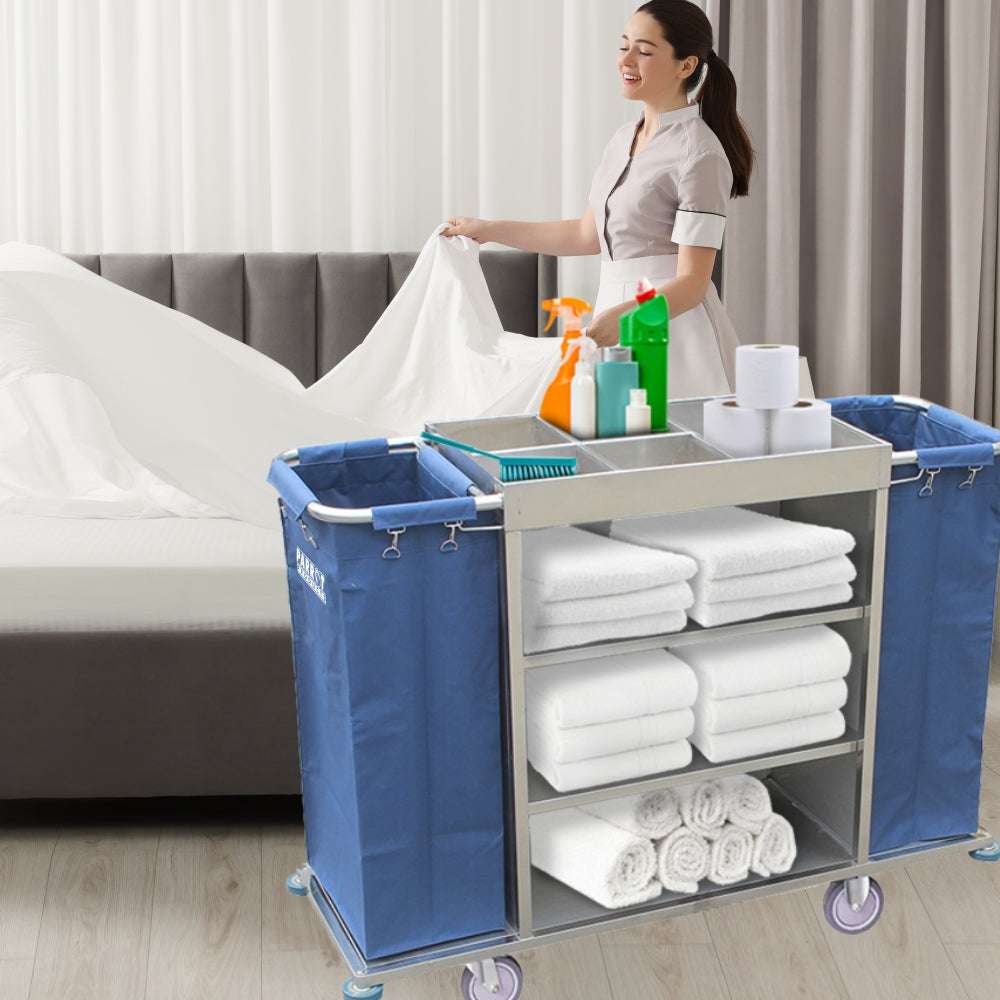 Person organizing cleaning supplies and towels on a cart in a bedroom.
