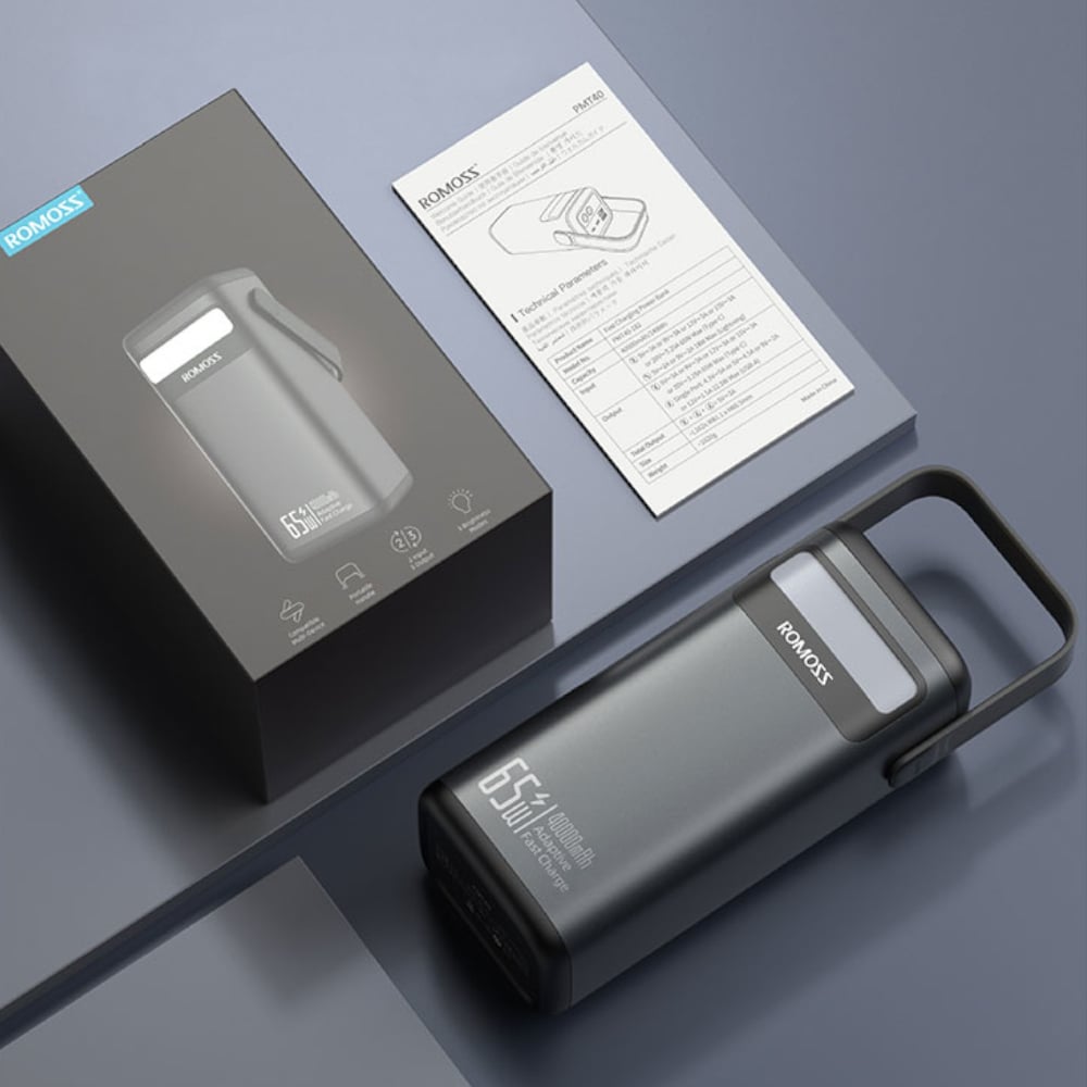 Power bank with packaging and manual on a gray background