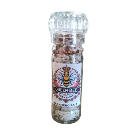 A clear glass grinder bottle labeled 'Queen Bee Chilli Creations Habanero Salt' containing a mix of habanero chilies, pink salt and spices.