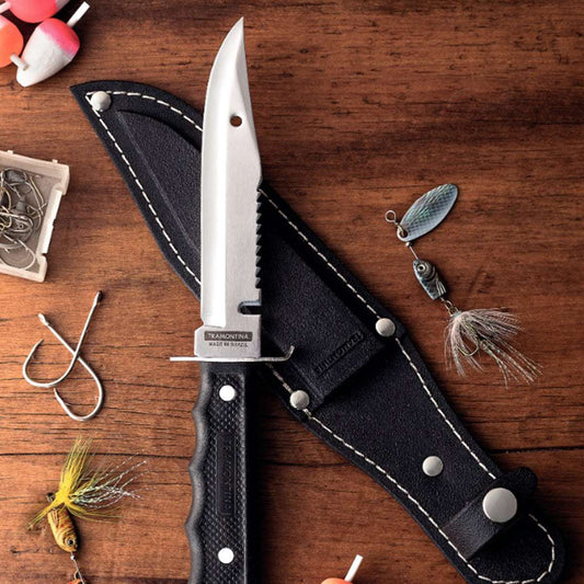 Fishing knife with sheath on a wooden surface with fishing lures and hooks.