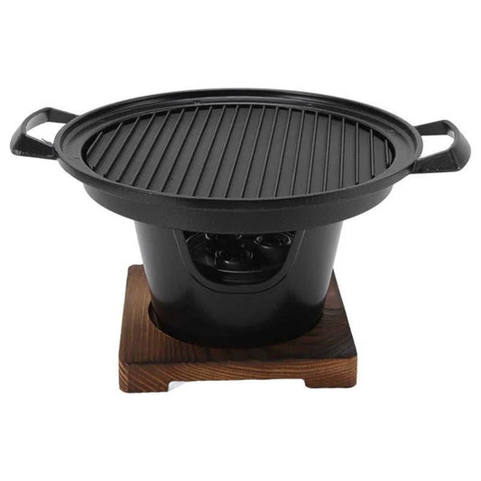 A black tabletop braai with a grill on top and a wooden base.