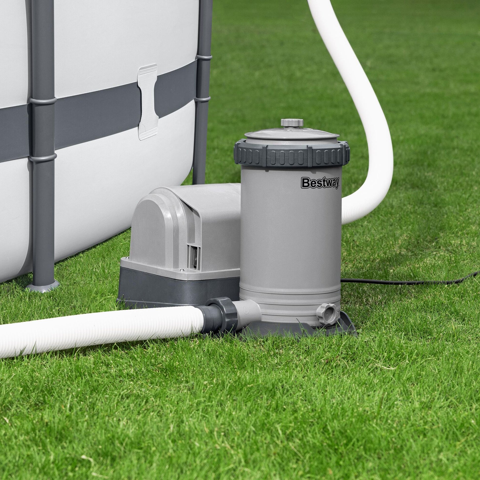 Pool pump and filter system on grass next to a pool.