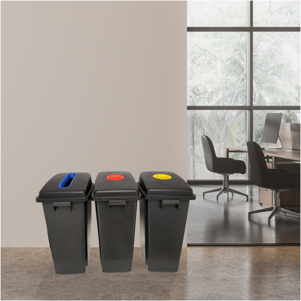 Three black recycling bins with color-coded lids in an office setting