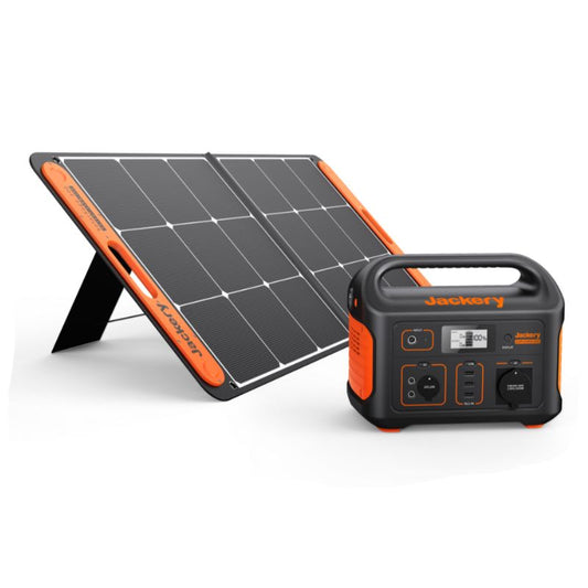 The image shows a portable power station with a black and orange color scheme, alongside a monocrystalline solar panel. The power station has multiple output ports and a display.