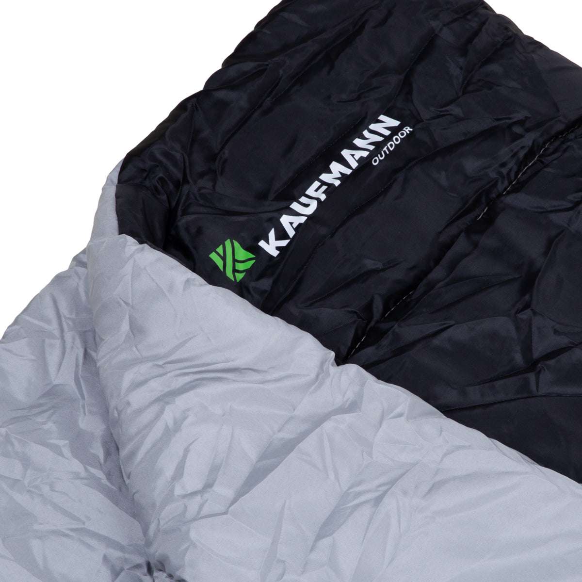 Close-up of a sleeping bag with 'Kaufmann Outdoor' branding on a white background