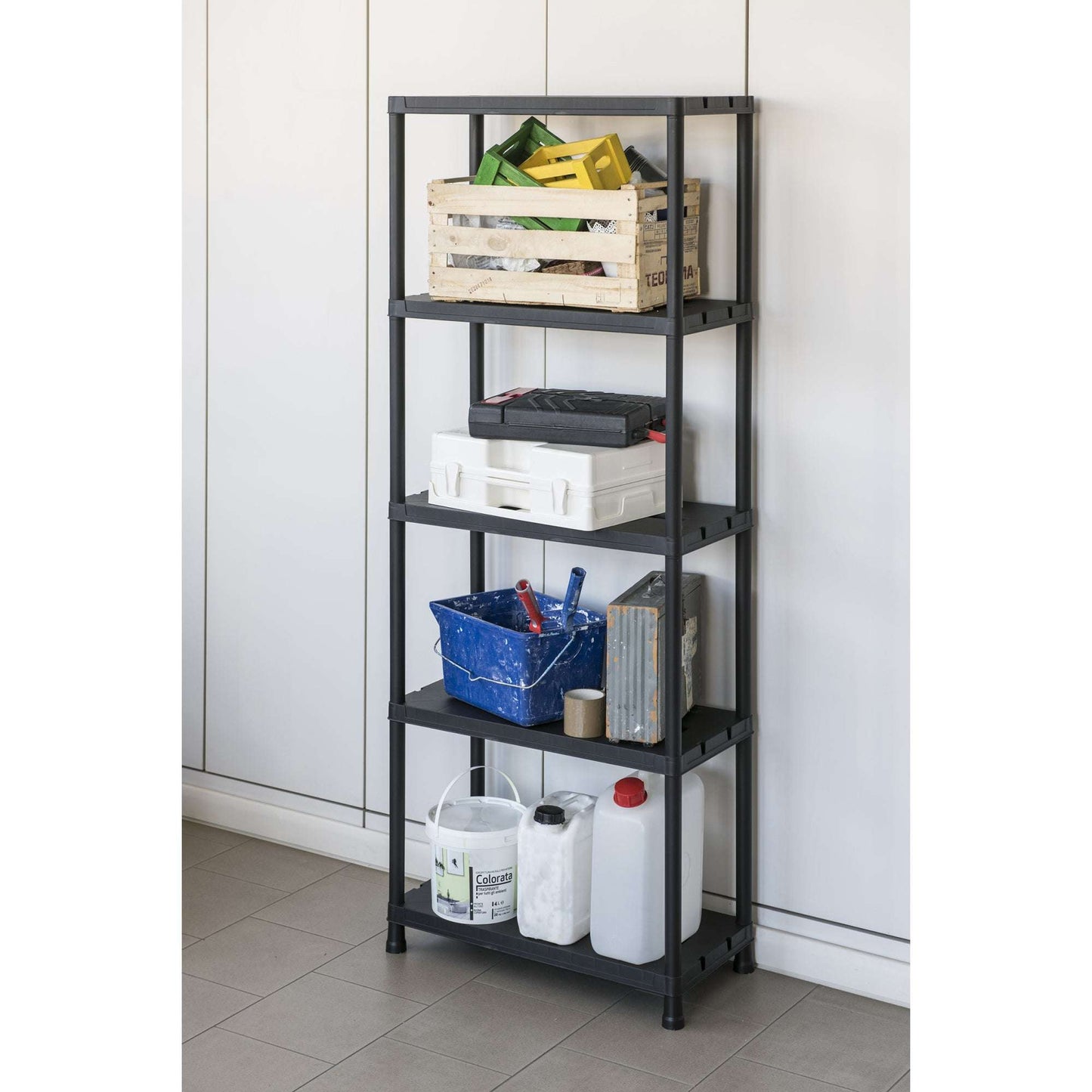 Black shelf with various items against a white wall