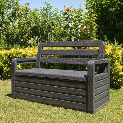 Black garden bench in a grassy area with greenery in the background
