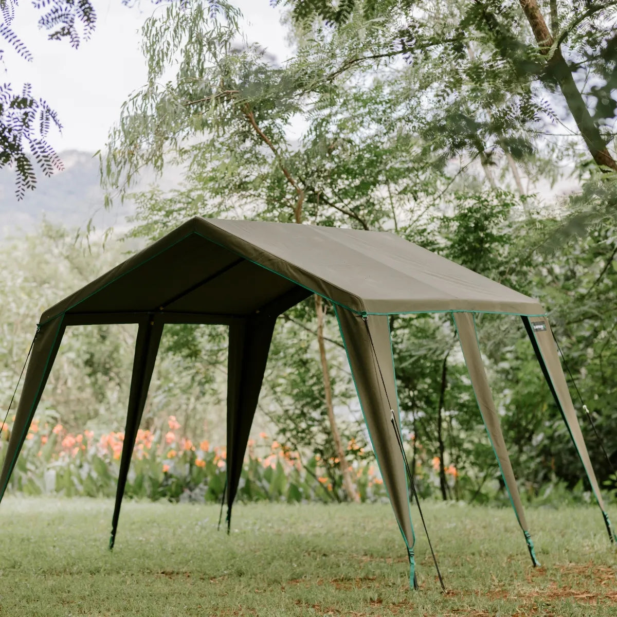 Portable canopy tent set up in a grassy area with trees in the background