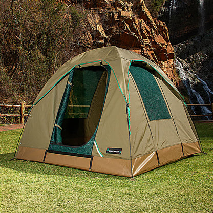 Green and brown tent set up outdoors with a waterfall in the background